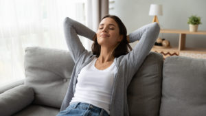 harrell king air quality experts woman sitting on couch breathing fresh air in her home